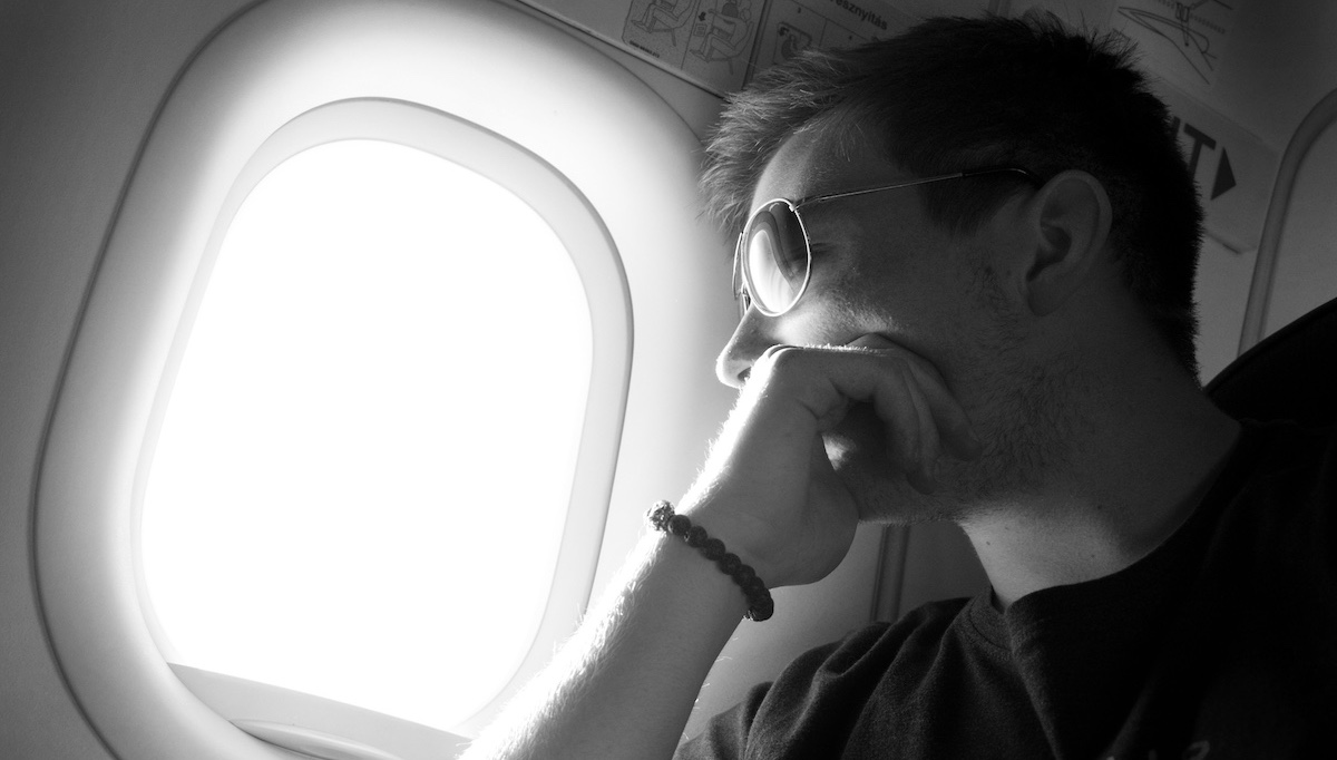 Zakladatel projektu, Lukáš na fotografii v letadle dívající se z okna.
